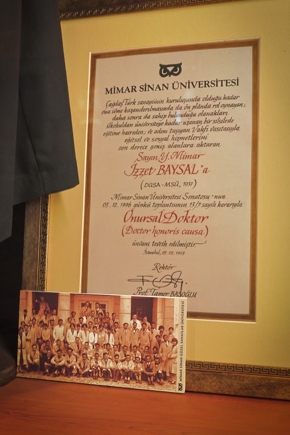 Mimar Sinan Üniversitesi'nin onursal doktora beratı ve önündeki mezuniyet kartı