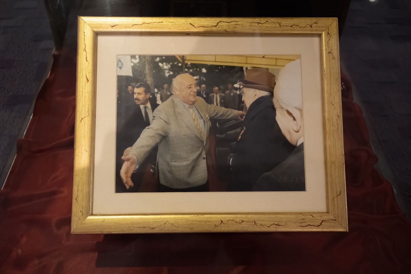 Bir törende konuklarla selamlaşmayı gösteren çerçeveli fotoğraf