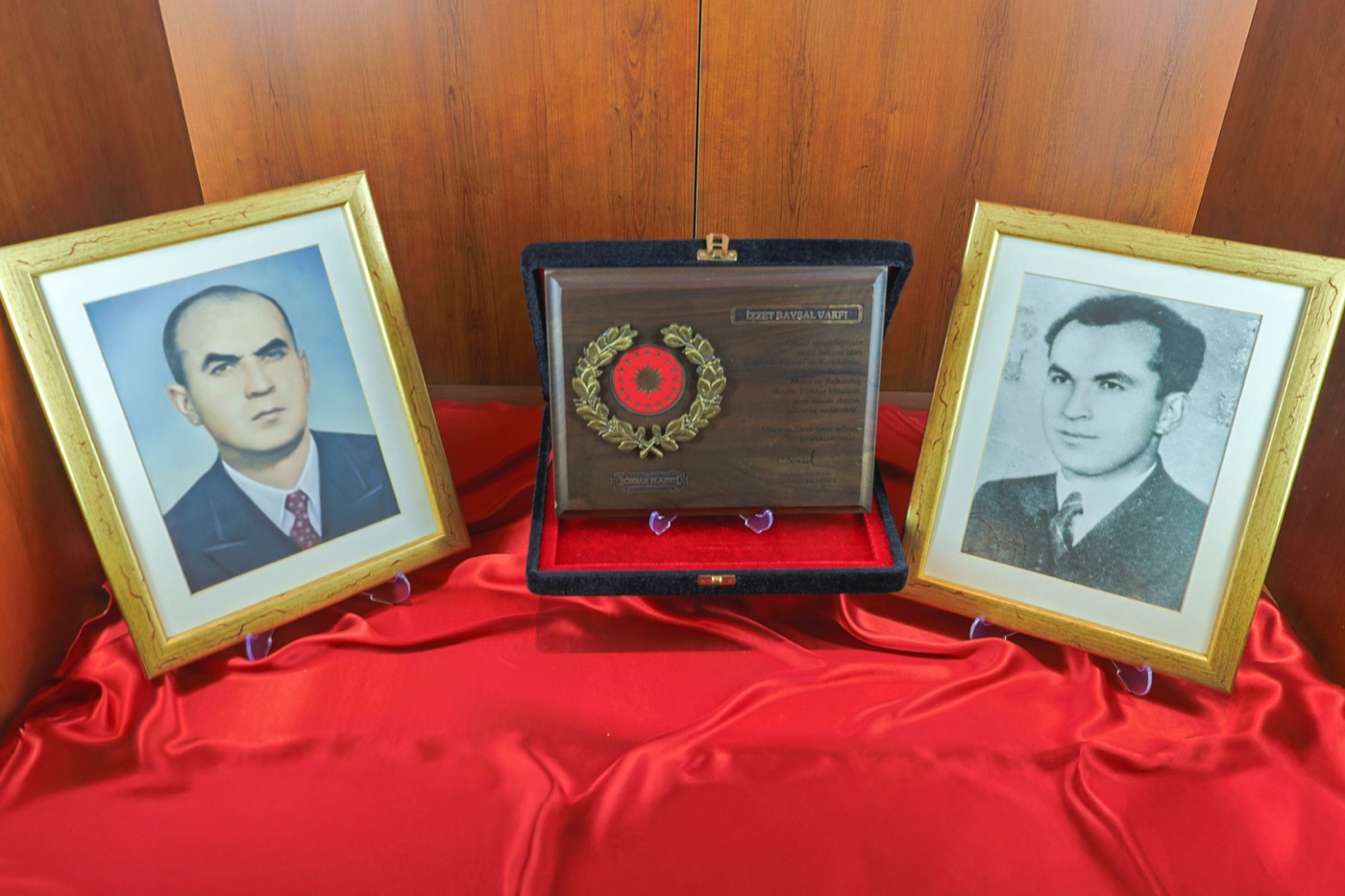 İki portrenin arasında sergilenen şükran plaketi